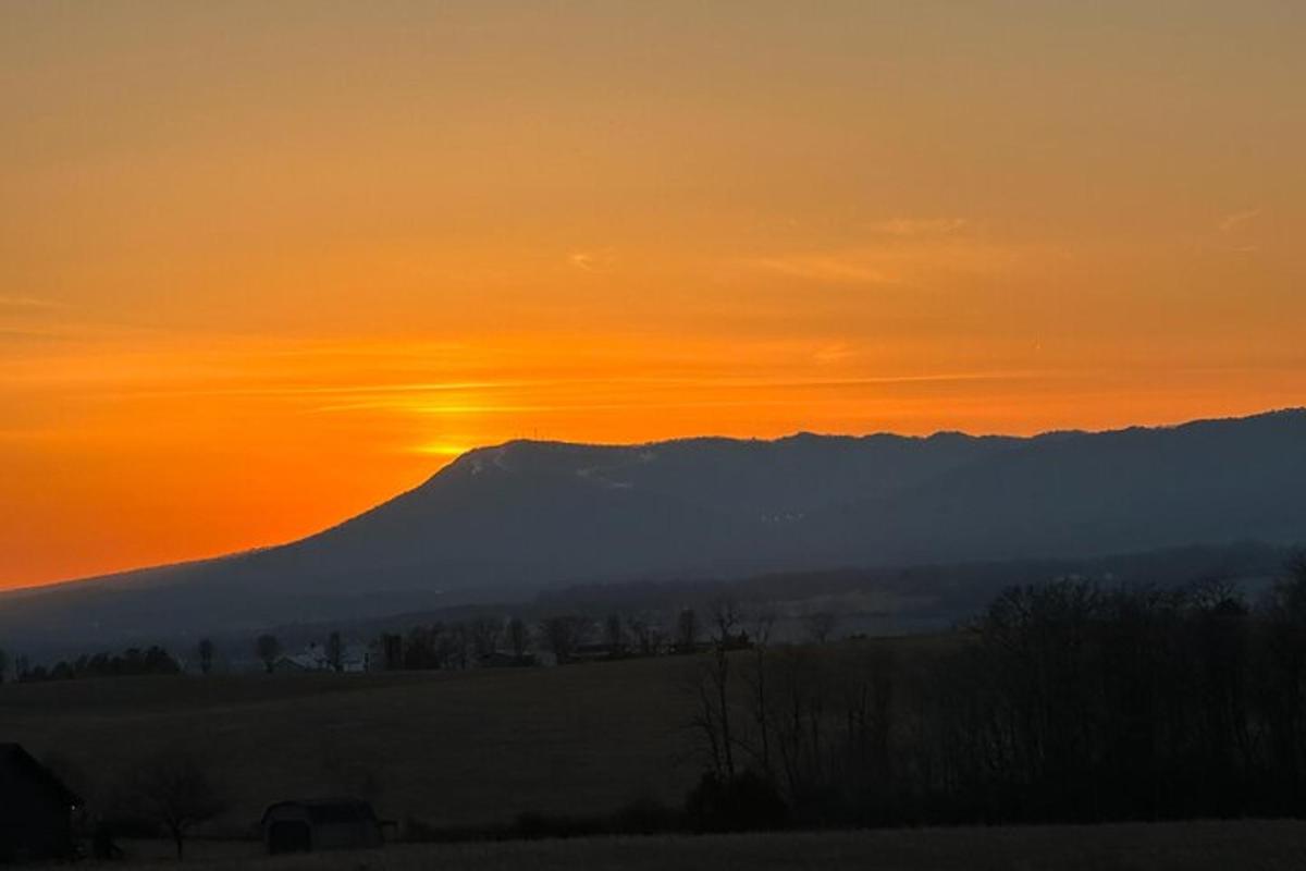 a sunset with a mountain in the background