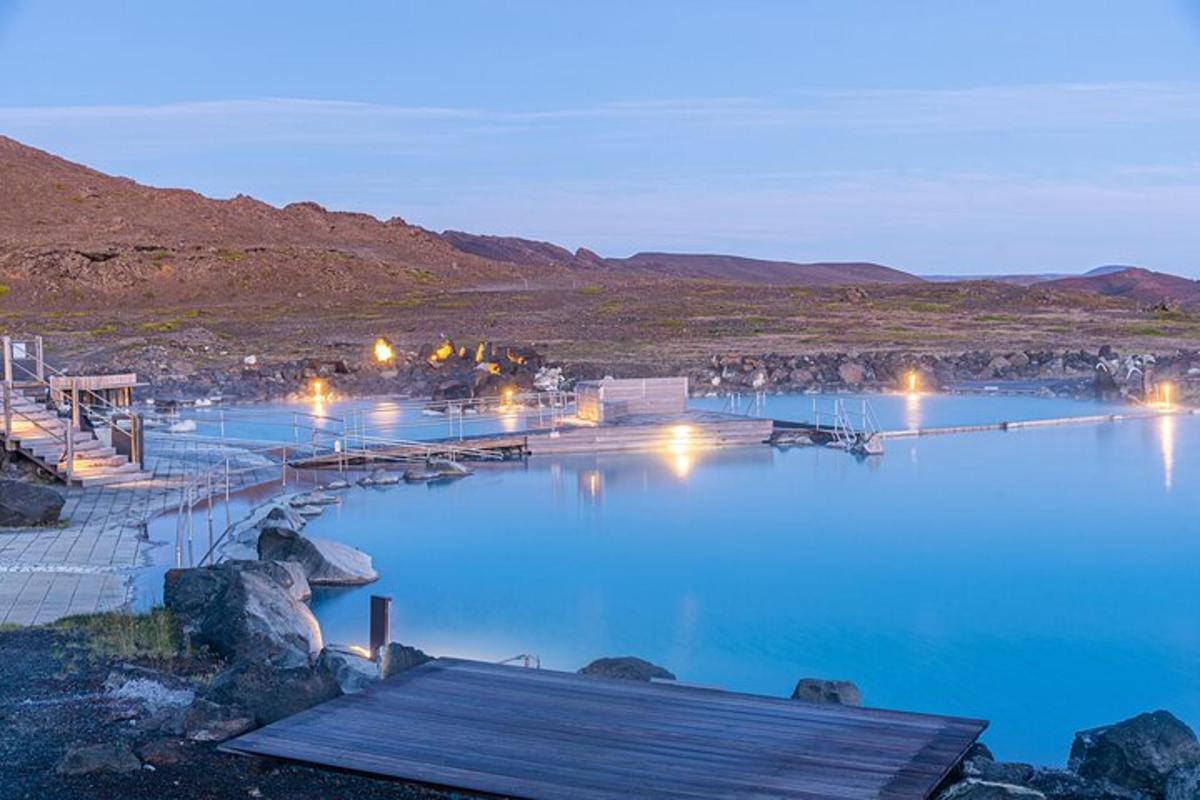Blár vatnspollur að nóttu til með ljósum