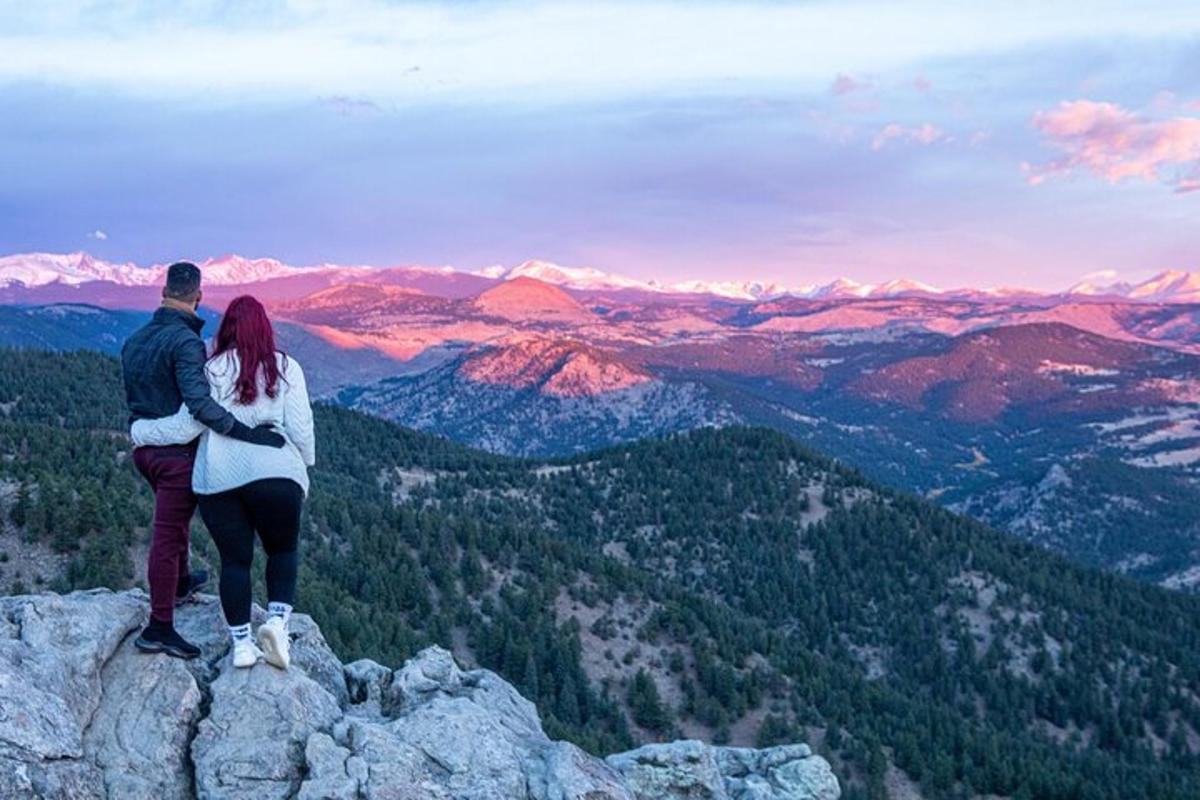 un uomo e una donna in piedi sulla cima di una montagna