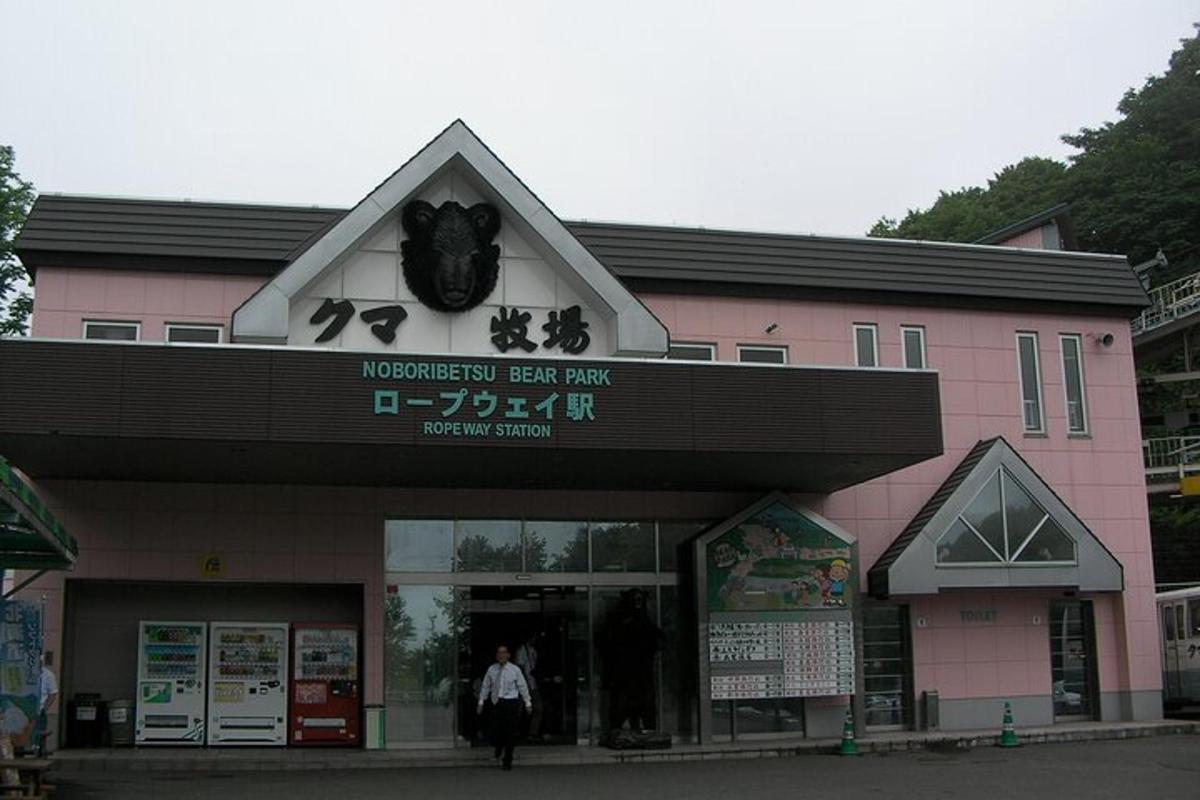 a woman walking in front of a pink building