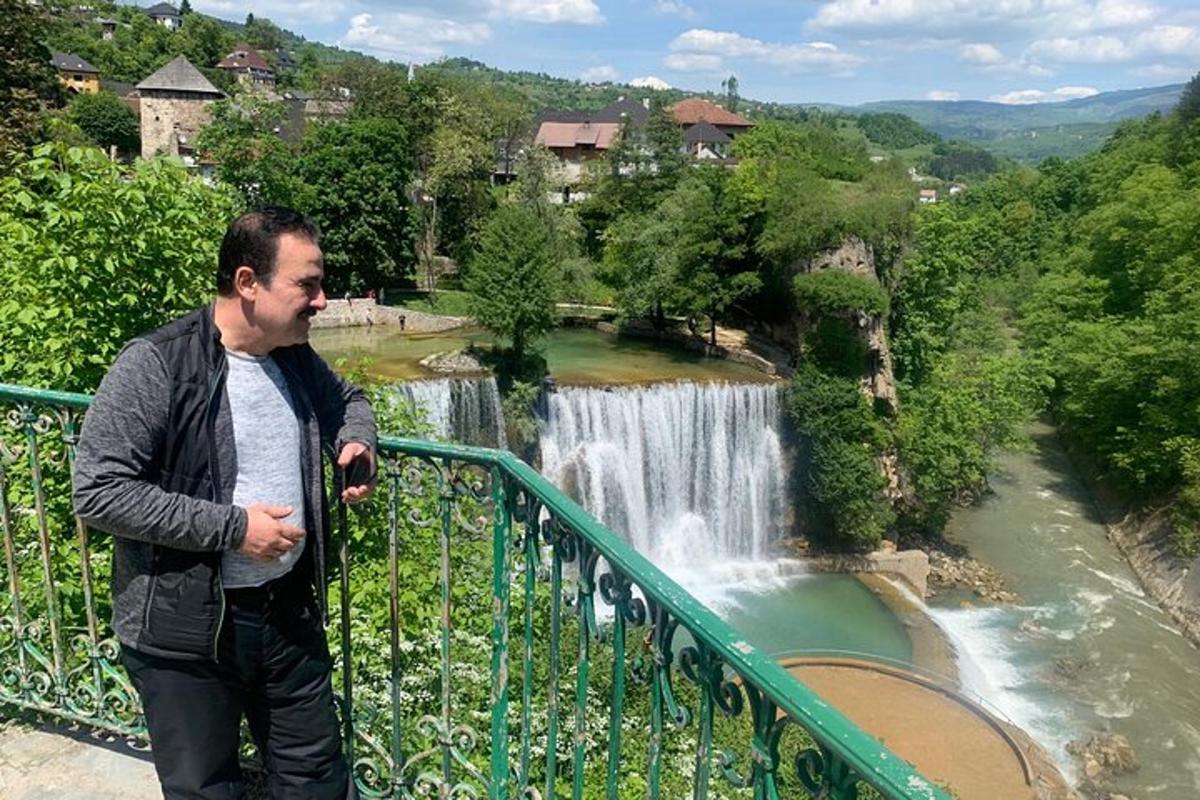 Ένας άντρας που στέκεται σε ένα μπαλκόνι κοντά σε έναν καταρράκτη