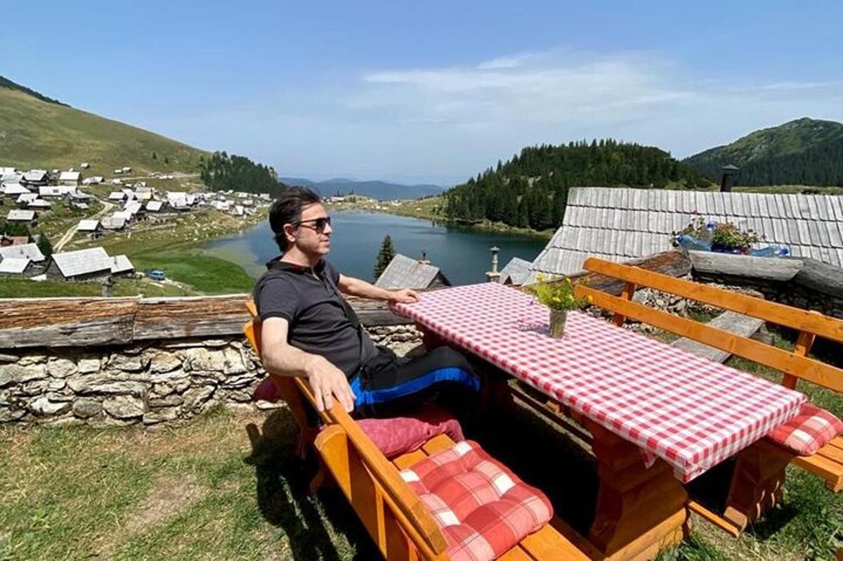 un uomo seduto a un tavolo da picnic con vista sul fiume