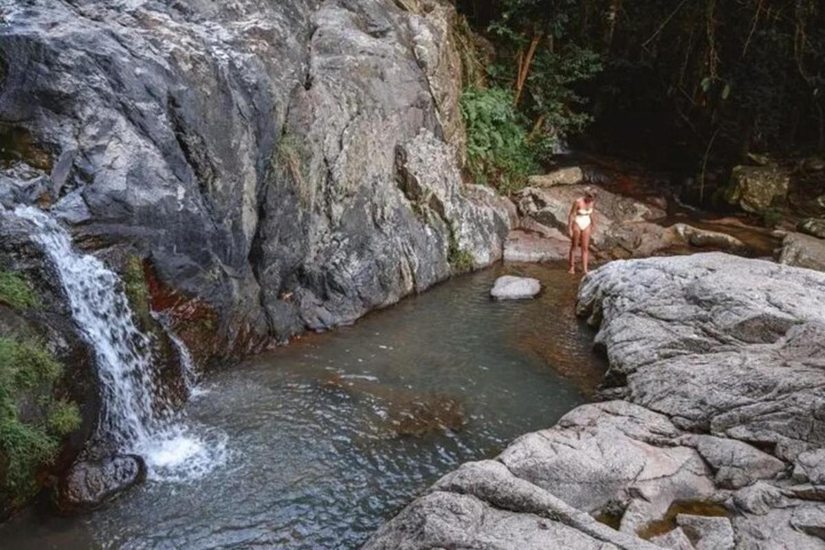 osoba stojící na skále poblíž vodopádu