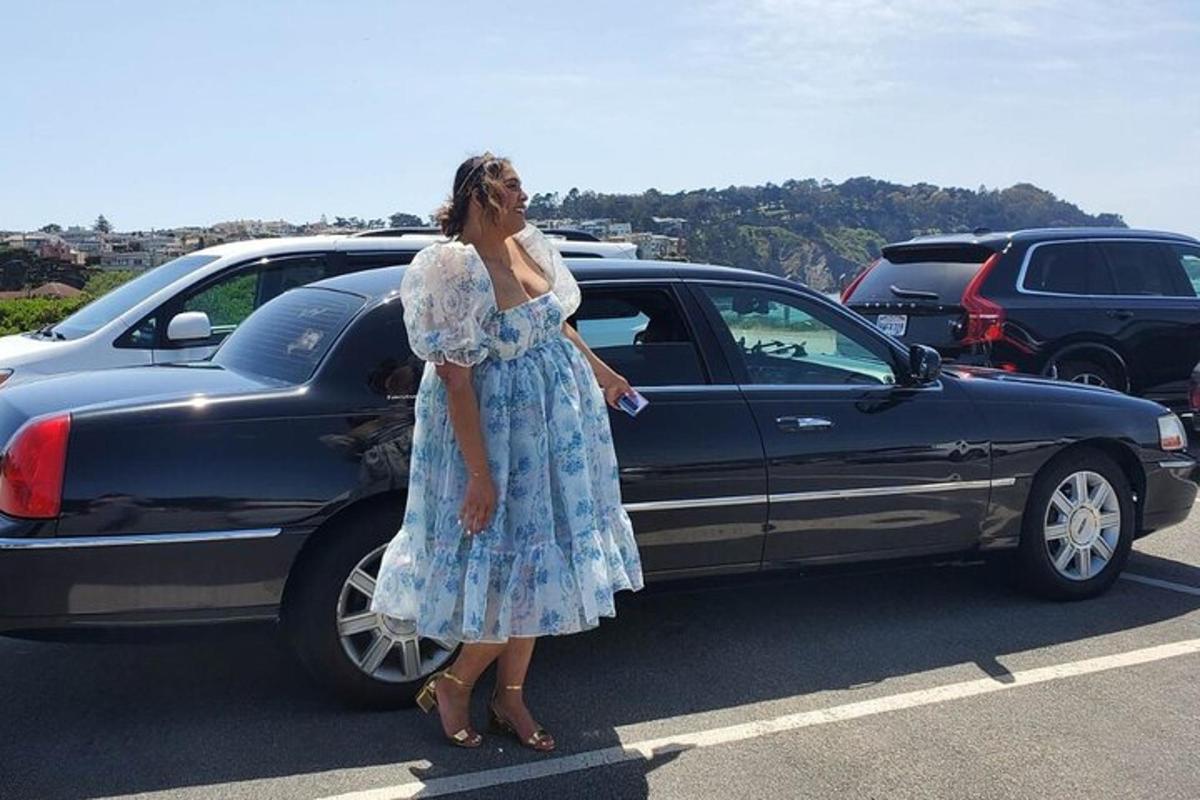 una donna in piedi accanto a un'auto in un parcheggio