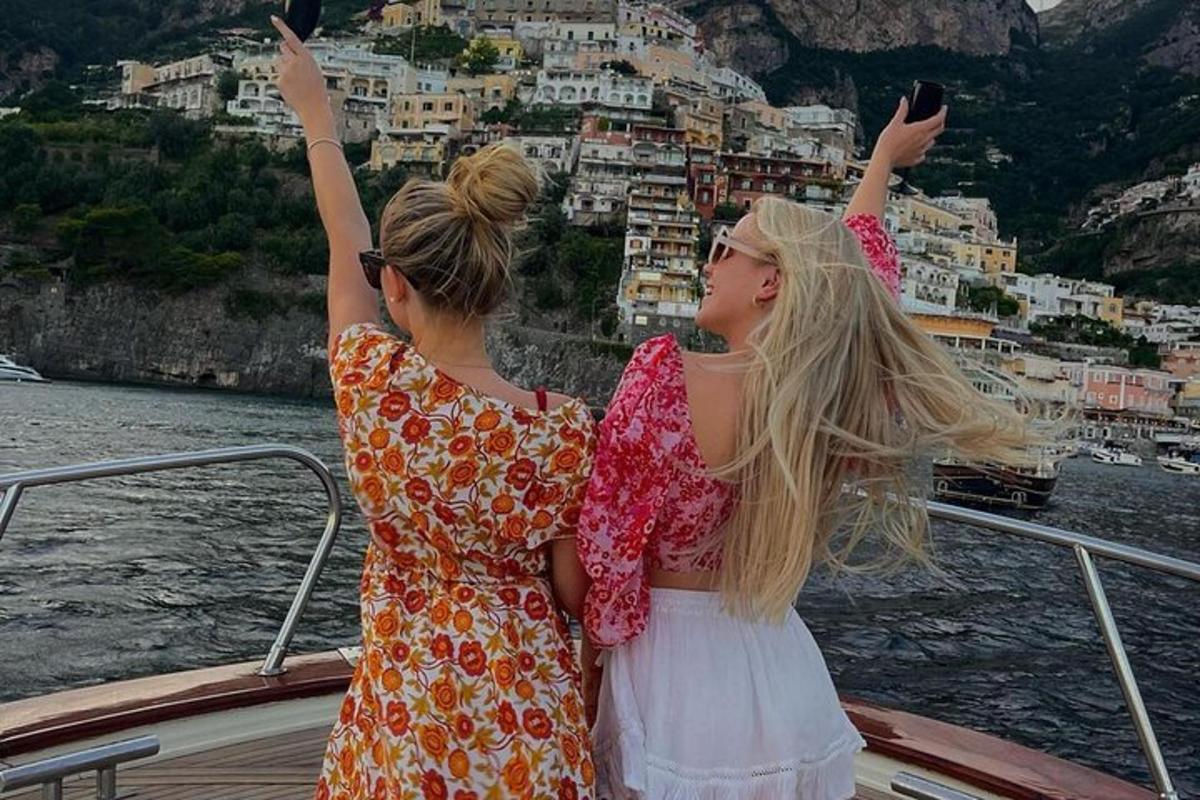 due donne in piedi su una barca che guardano la città