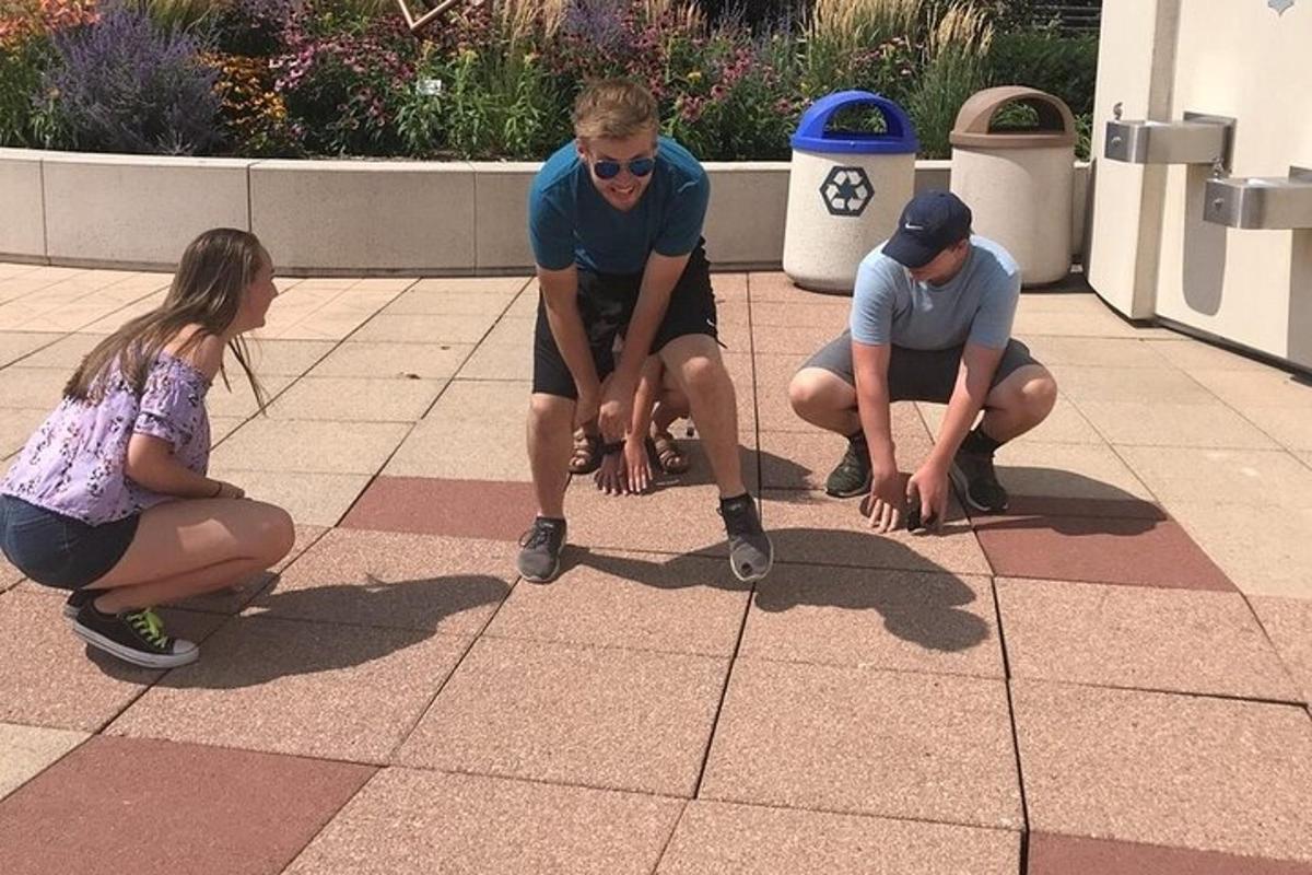 un gruppo di tre persone inginocchiate su un pavimento piastrellato