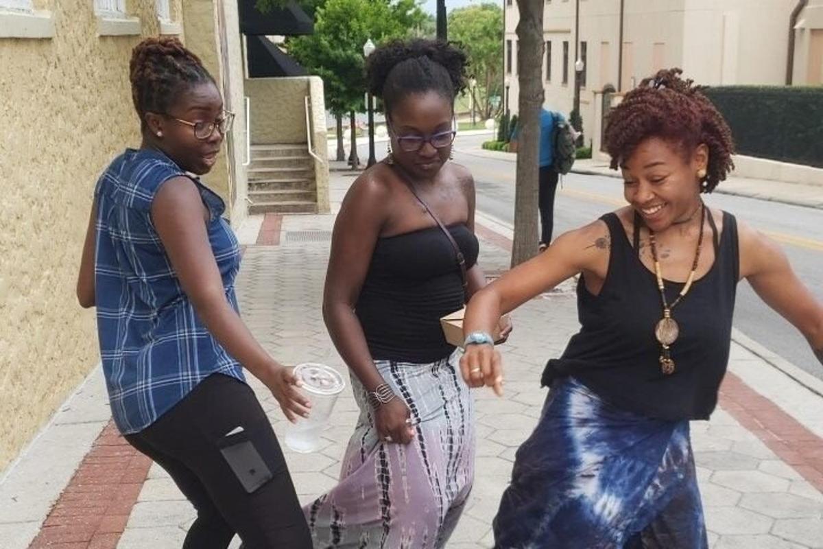 un gruppo di tre donne che camminano lungo un marciapiede