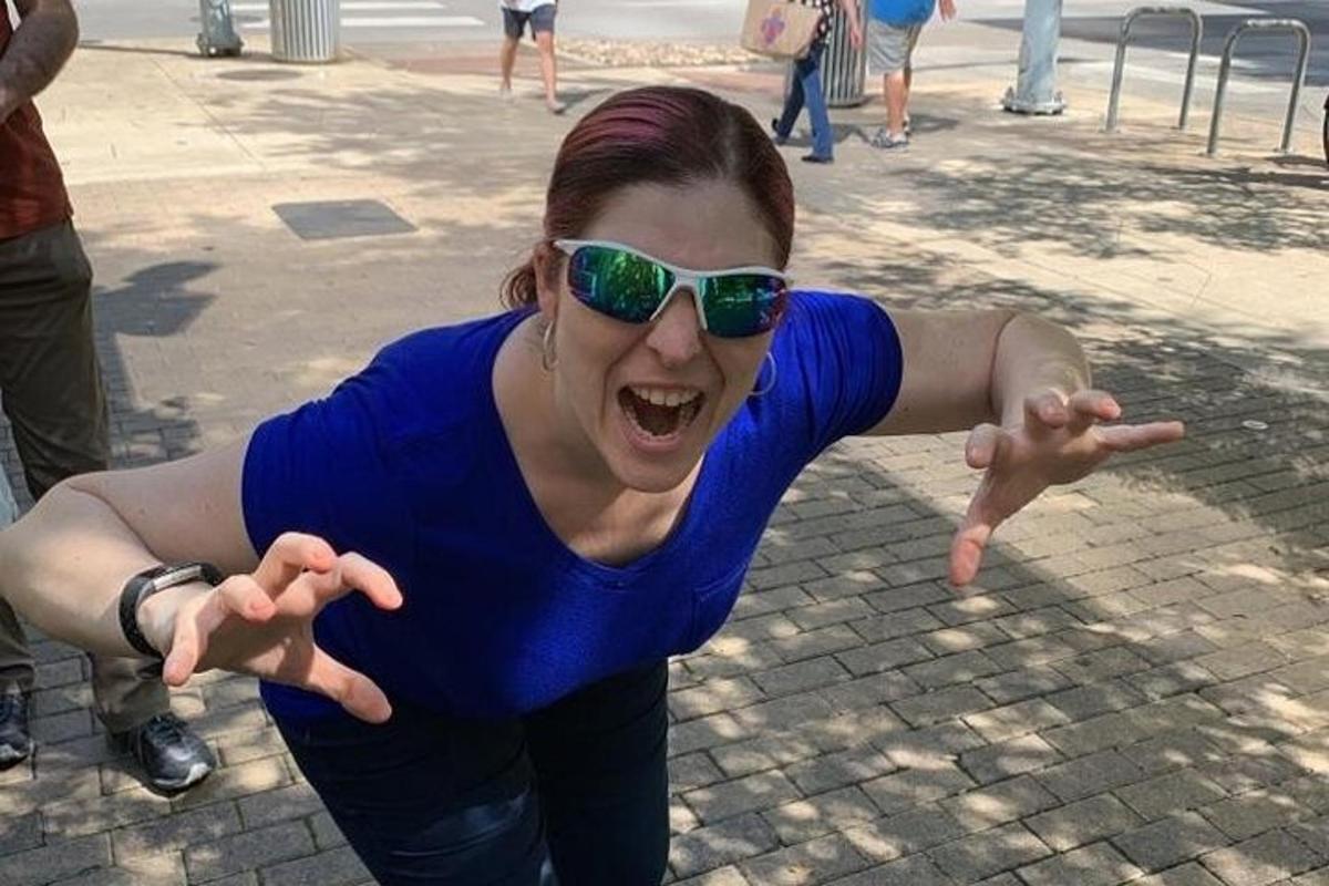 una donna con occhiali da sole sta ballando per strada