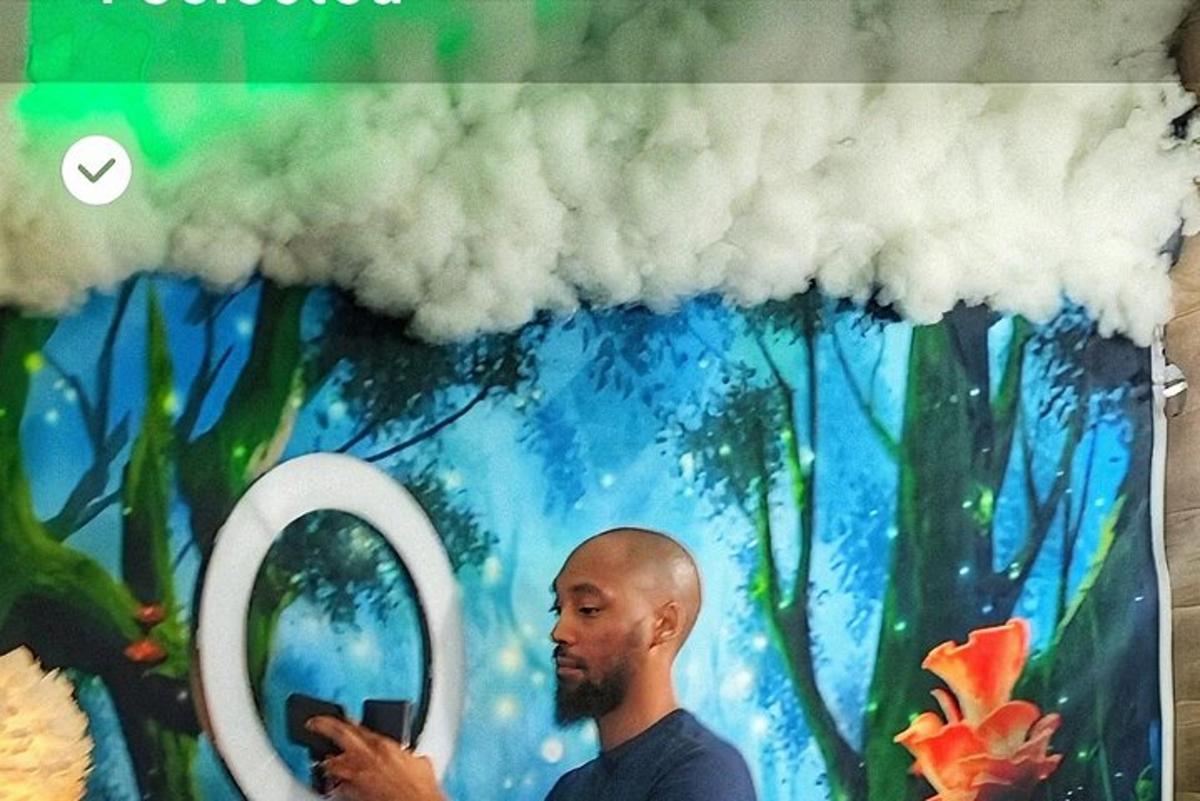een man die naar zijn mobiele telefoon kijkt voor een wolk