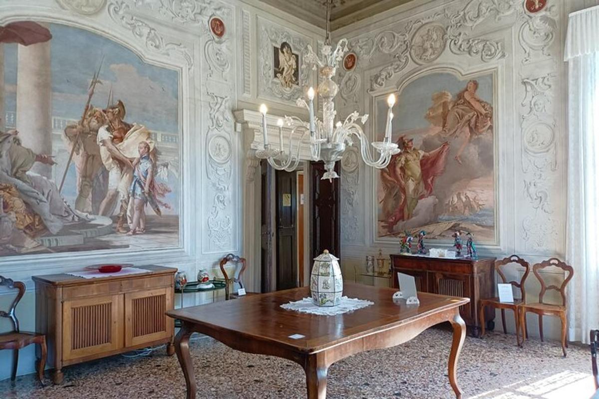 a dining room with a table and paintings on the walls