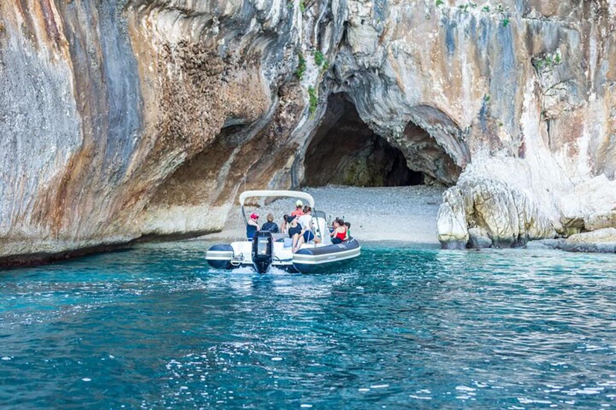 a group of people on a boat in front of a cave