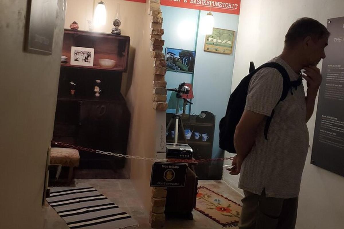 un home amb una motxilla mirant una exposició en un museu