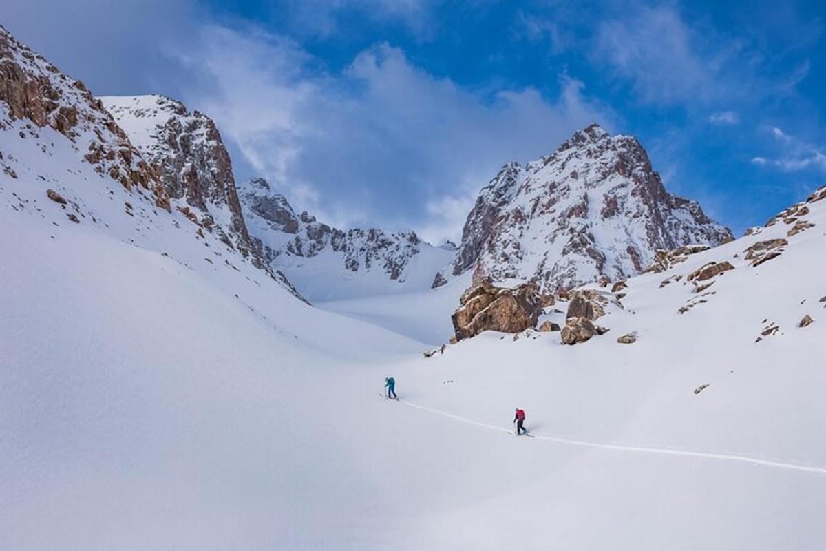 due persone che sciano giù da una montagna innevata