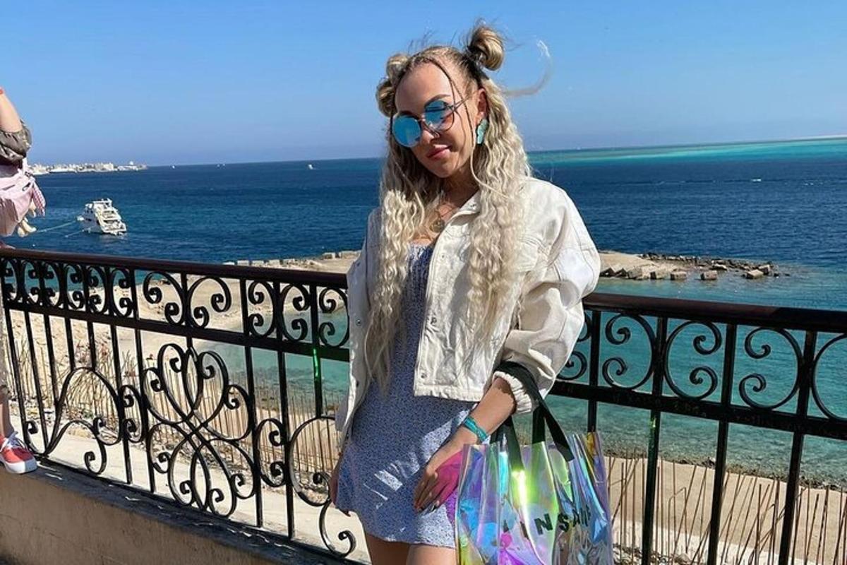 Μια γυναίκα στέκεται σε ένα μπαλκόνι κοιτάζοντας τον ωκεανό