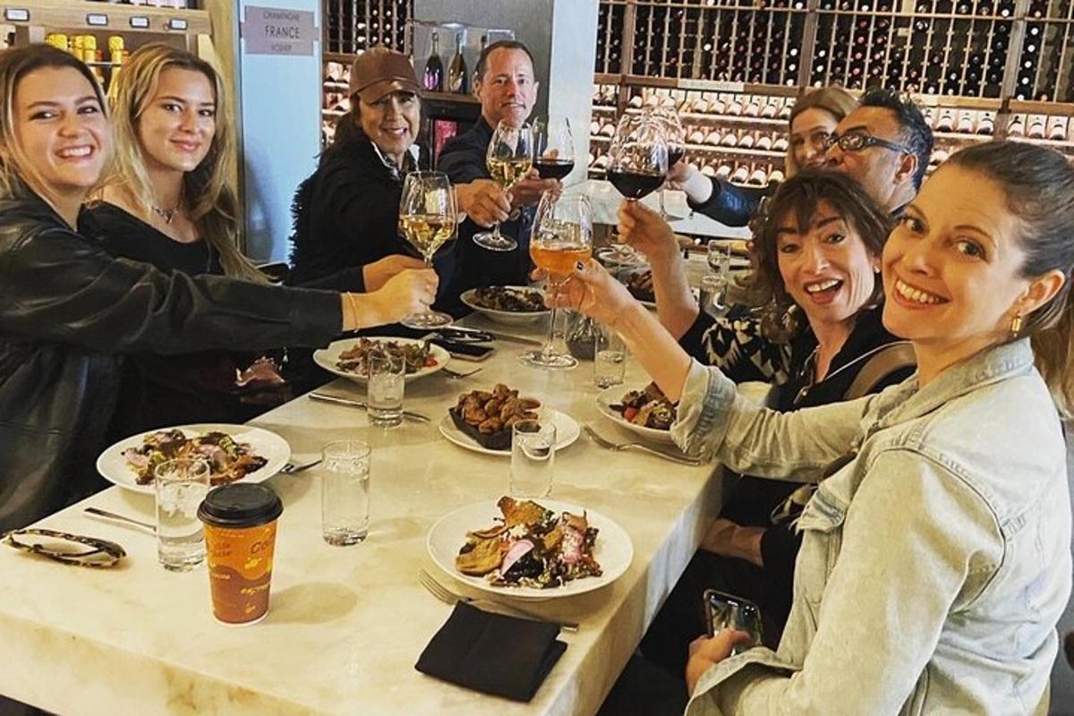 a group of people sitting around a table with wine glasses