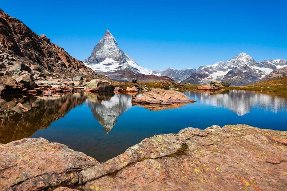 a mountain reflection in a lake with snow covered mountains
