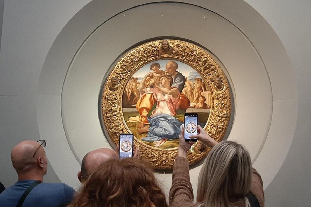 pessoas tirando fotos de uma pintura em um museu