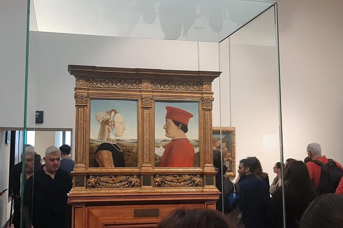 um grupo de pessoas em pé ao redor de uma pintura de um homem