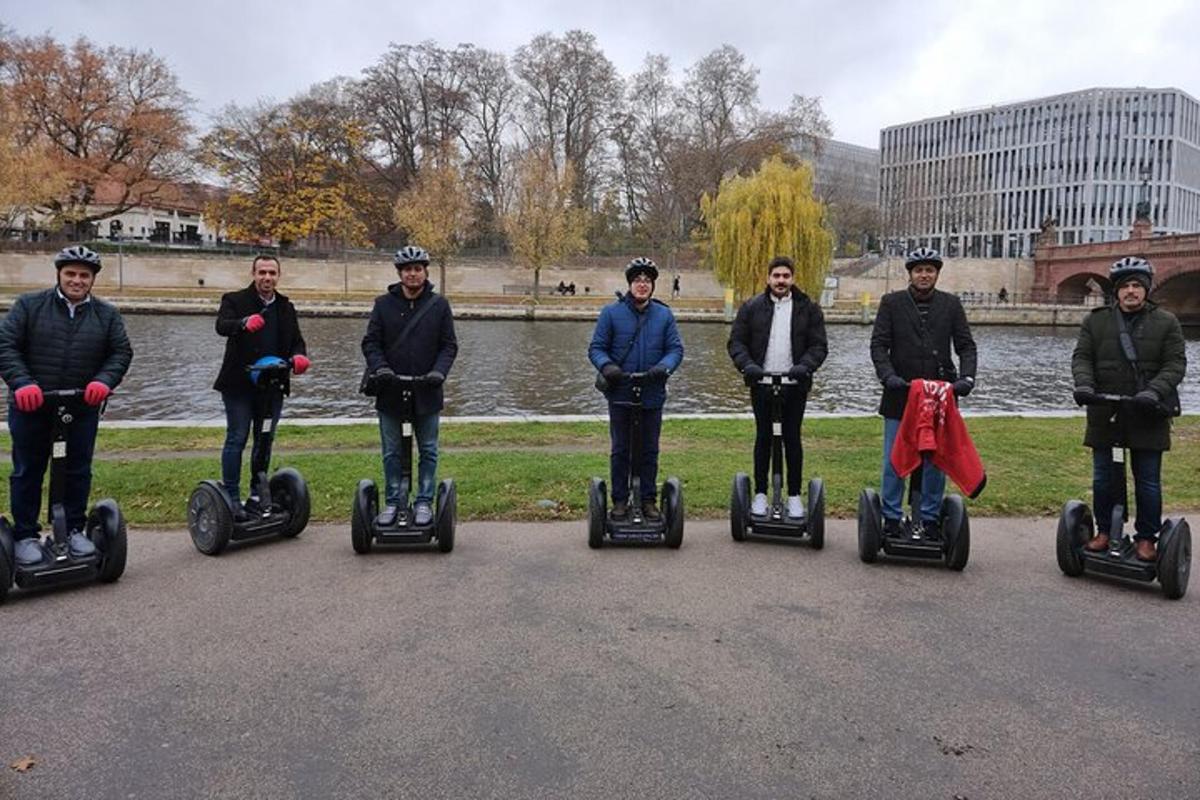 un grup de oameni care călătoresc cu Segway-uri într-un parc