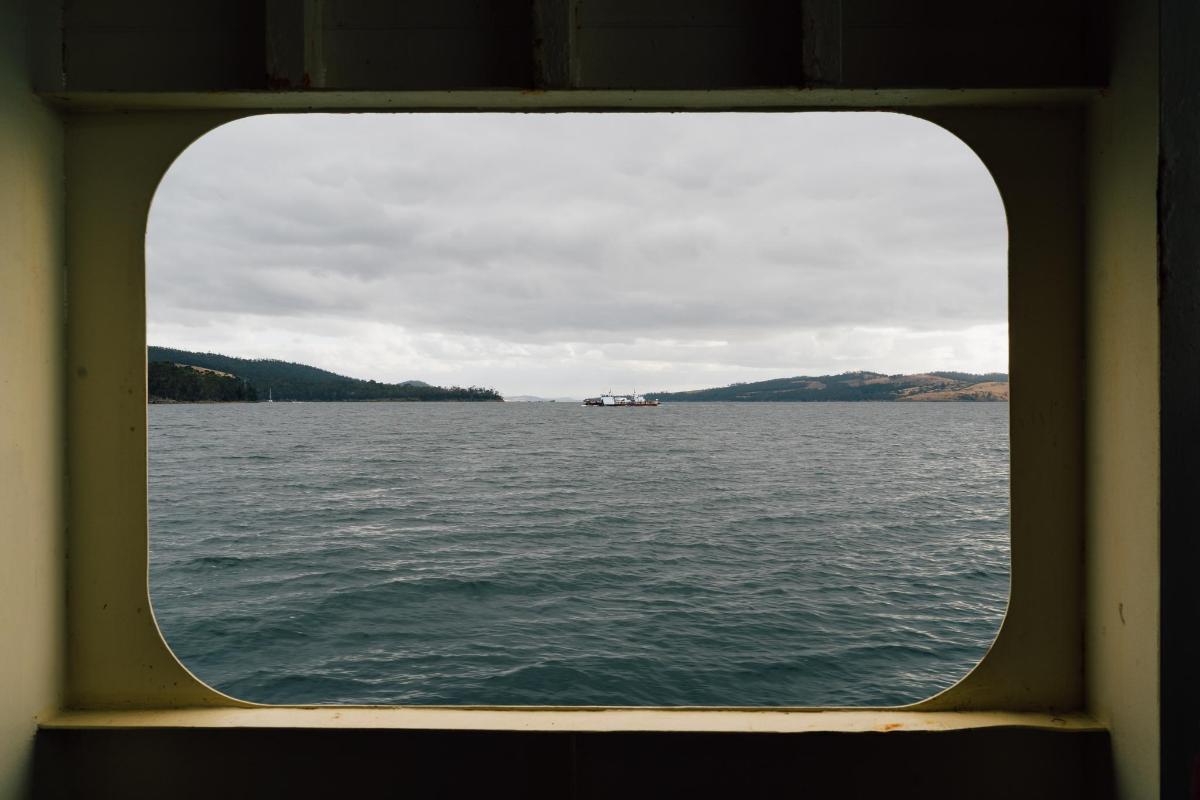 uma vista da água através de uma janela de um barco