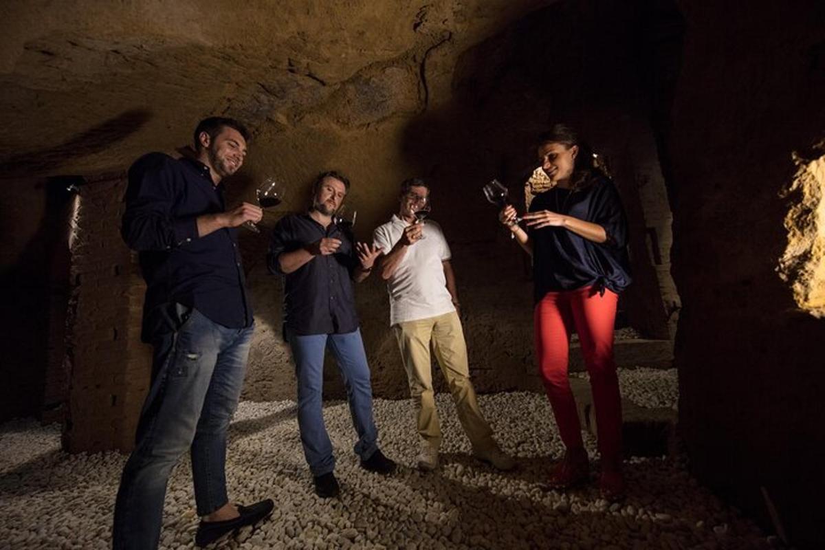 un gruppo di persone che bevono vino in una grotta