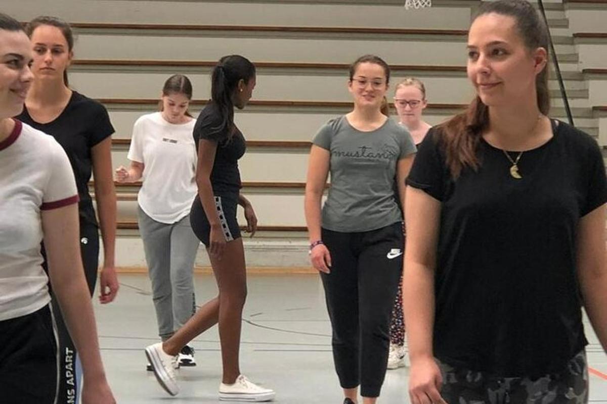 Un grupo de chicas de pie en un gimnasio.