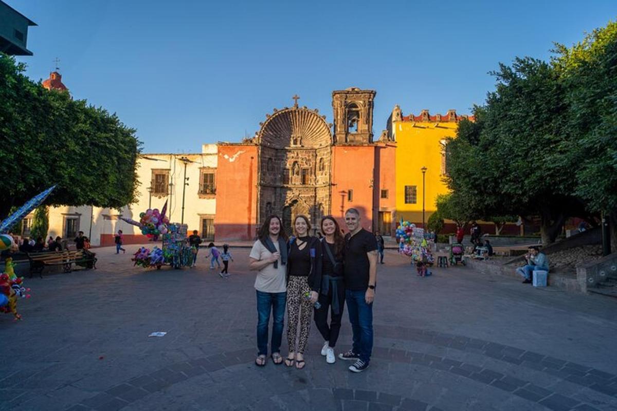 tres persones posant per a una foto davant d'un edifici