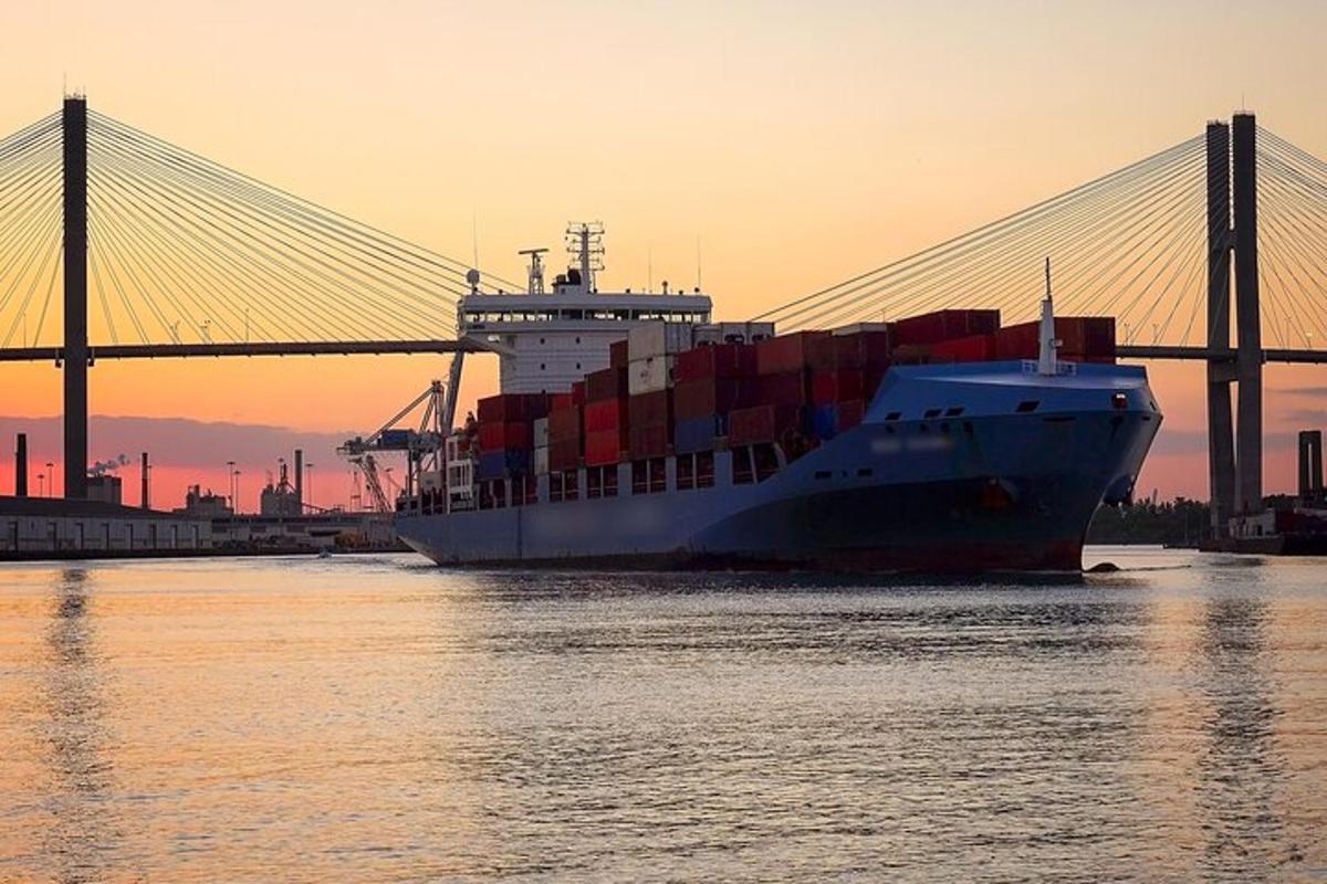 a container ship is docked next to a bridge