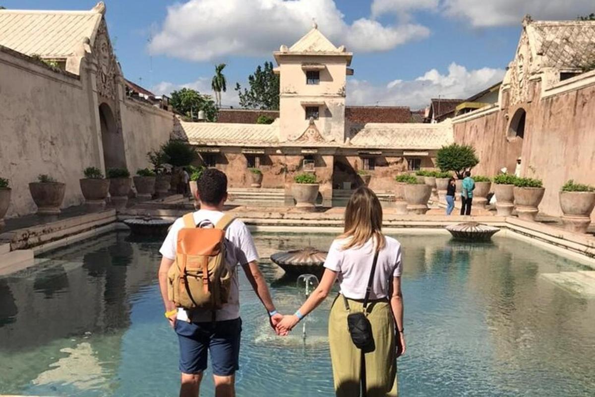 un bărbat și o femeie ținându-se de mână în timp ce se plimbă printr-o curte interioară