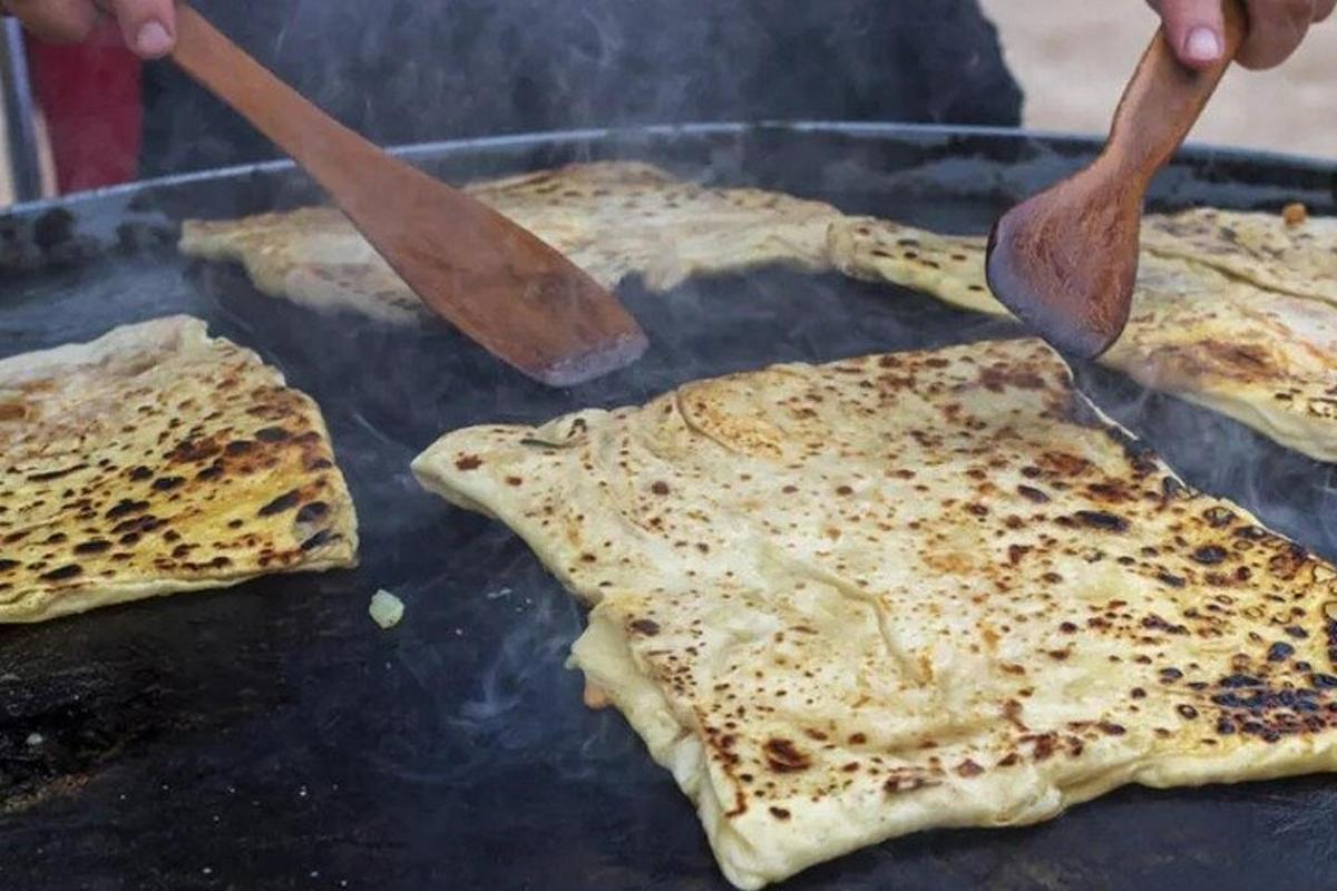 osoba vaří jídlo na grilu pomocí špachtlí