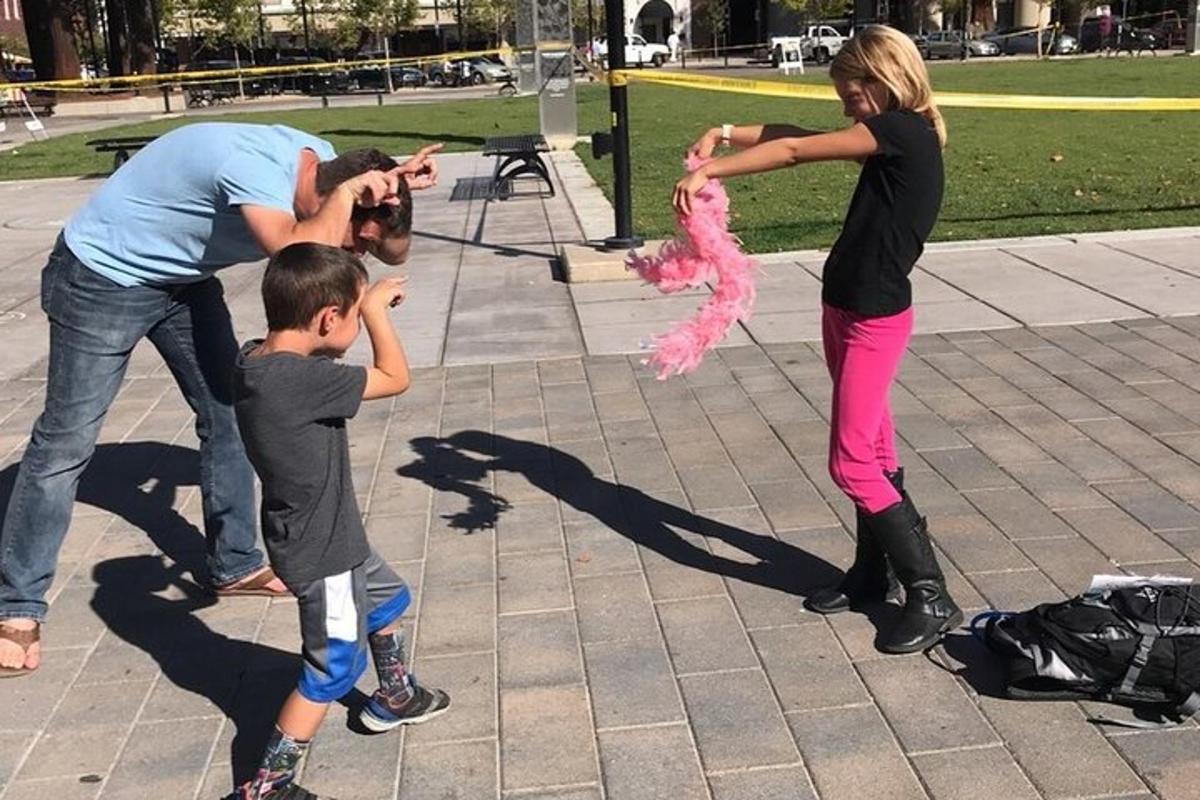 a group of people playing with a pink stuffed animal
