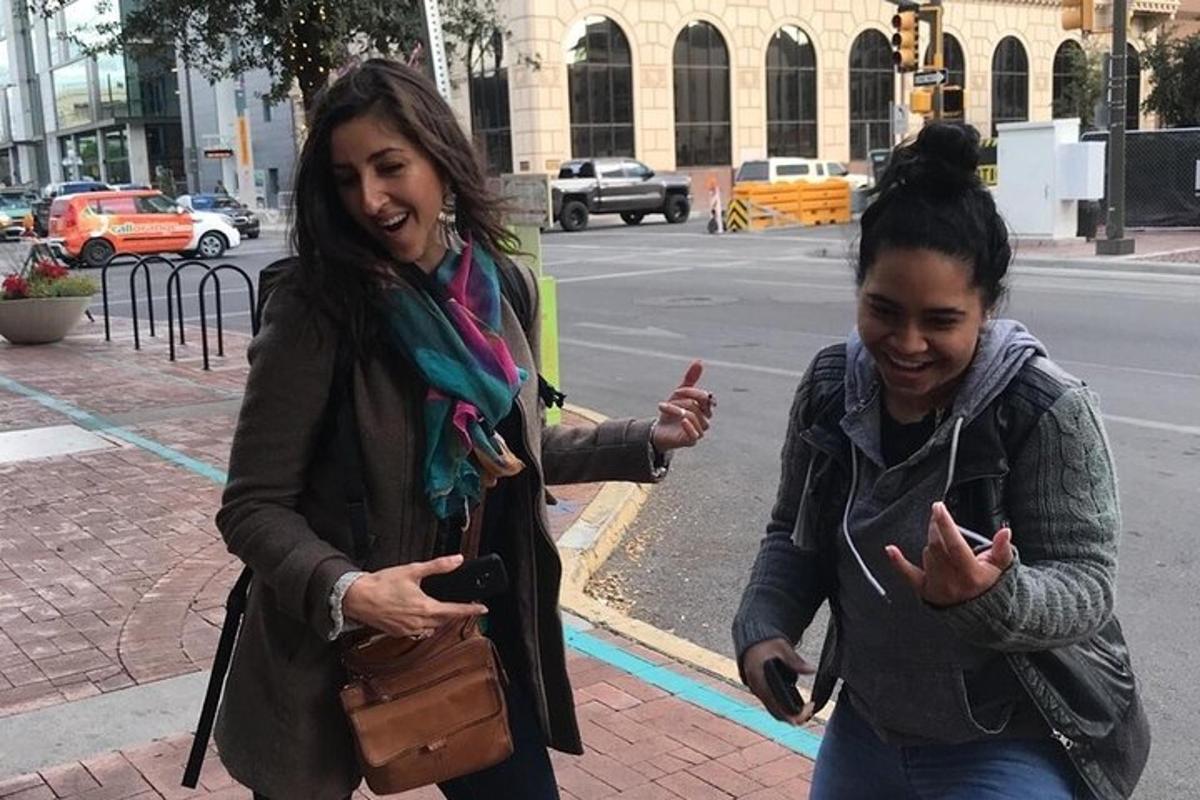 two women walking down the street looking at their cell phones