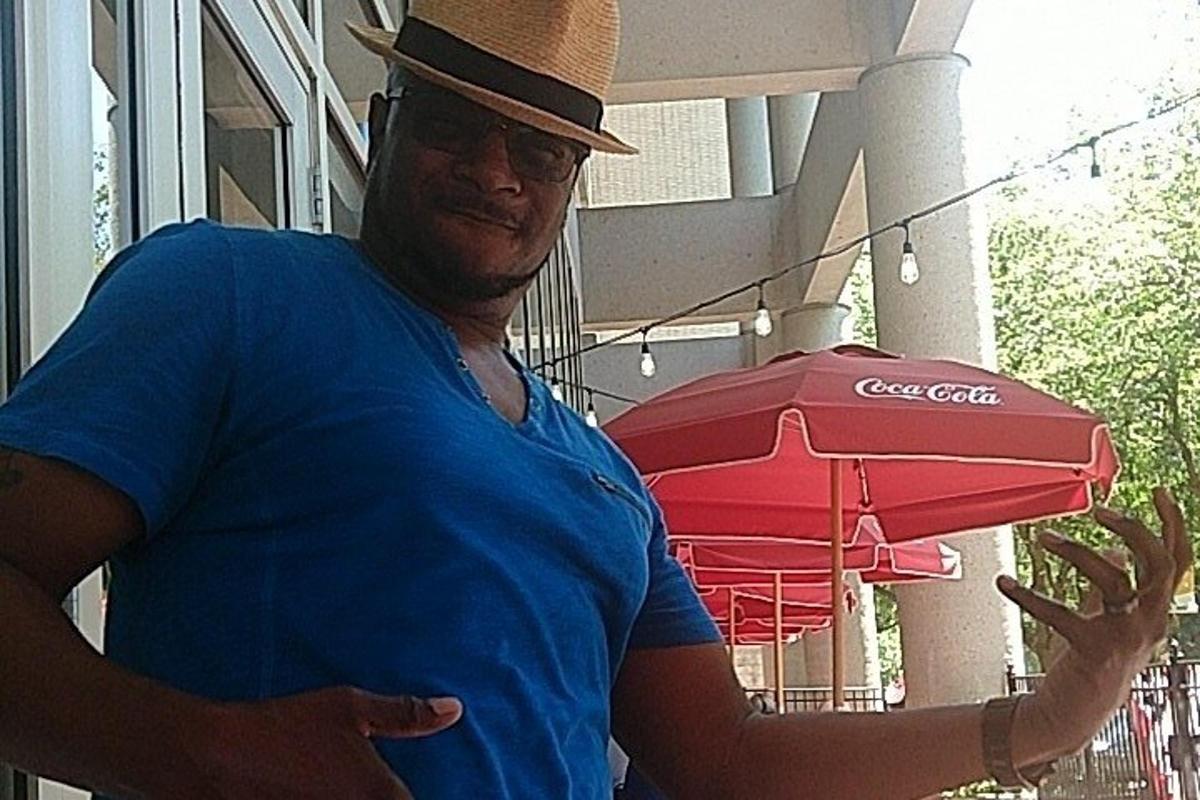 a man in a hat holding a red umbrella