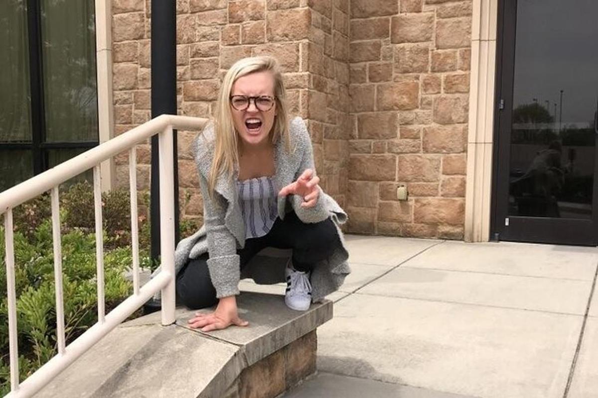 Una mujer arrodillada en las escaleras de un edificio