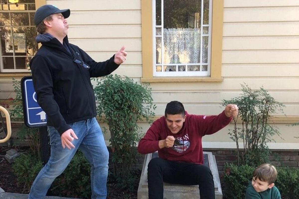 dos hombres de pie frente a una casa