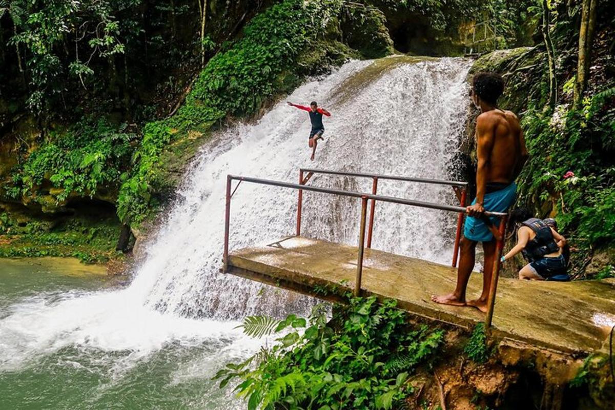 due persone in piedi su una piattaforma di legno di fronte a una cascata