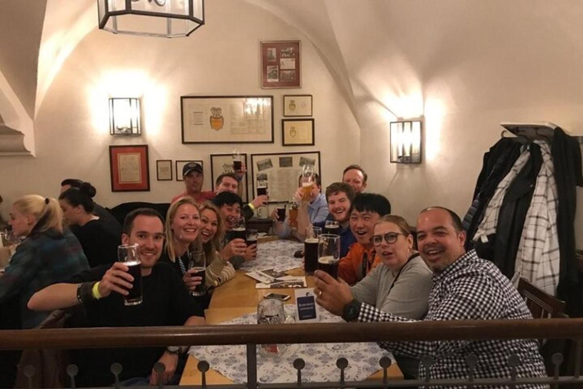 een groep mensen die aan een tafel zitten met drankjes