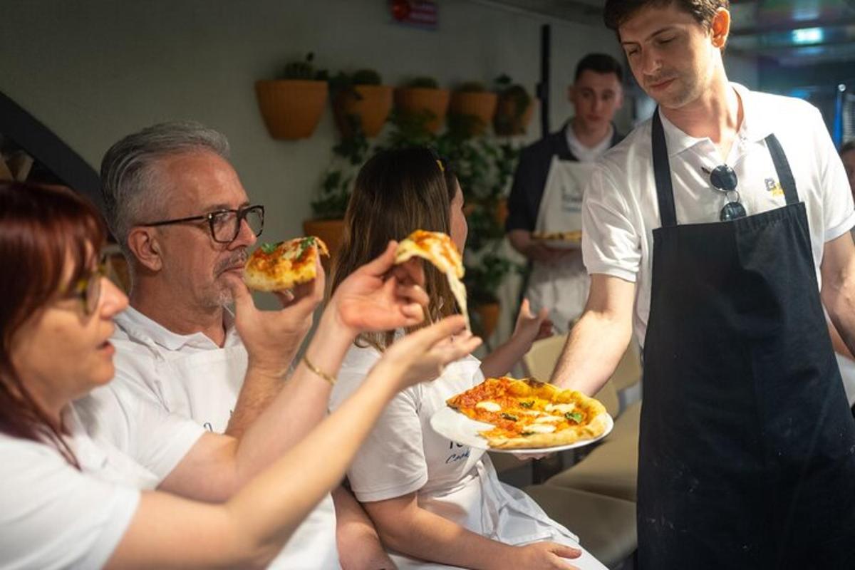 un grup de persones menjant un tros de pizza