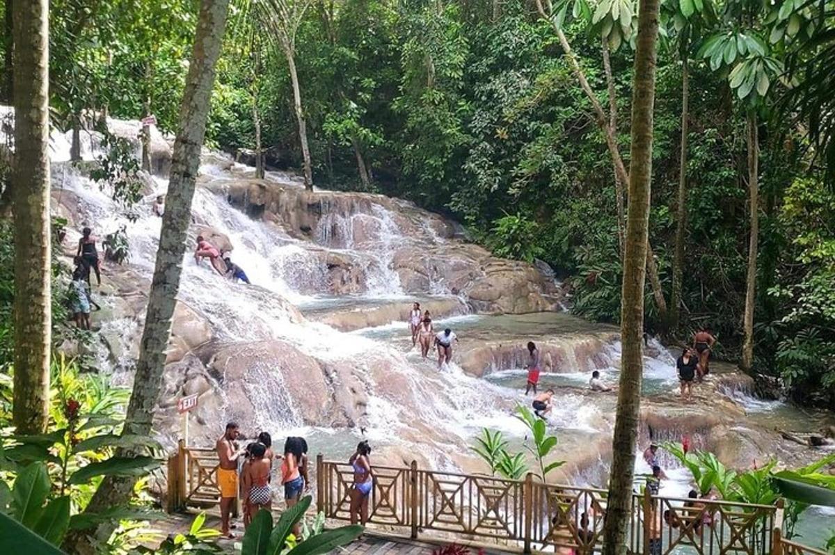 um grupo de pessoas em pé em frente a uma cachoeira