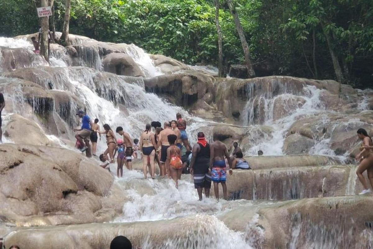 um grupo de pessoas em pé em uma cachoeira