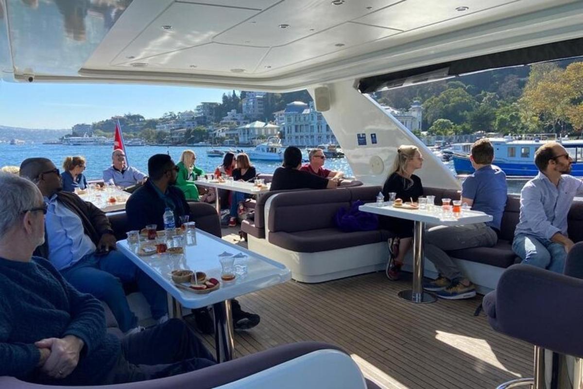 een groep mensen die aan tafels op een boot zitten
