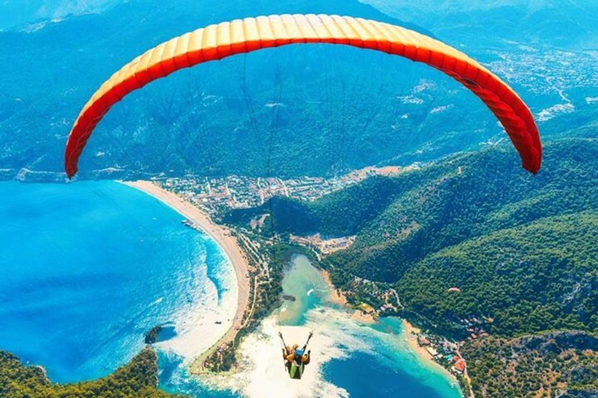 oseba, ki leti s padalom nad plažo