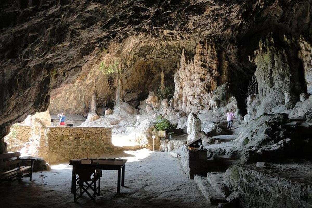 uma caverna com uma mesa em frente a um penhasco