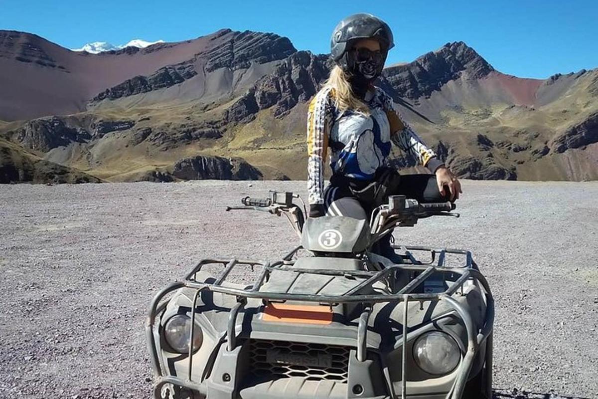 un bărbat stă pe un ATV în deșert