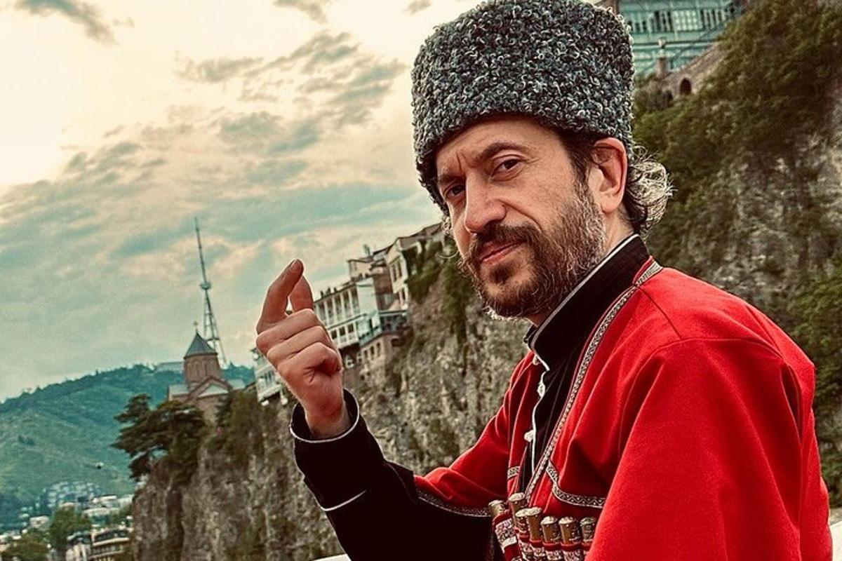 un bărbat purtând o pălărie stând pe un munte