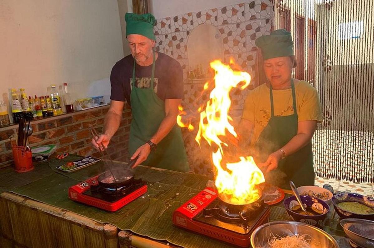 paar inimest seisab tulega grilli ümber
