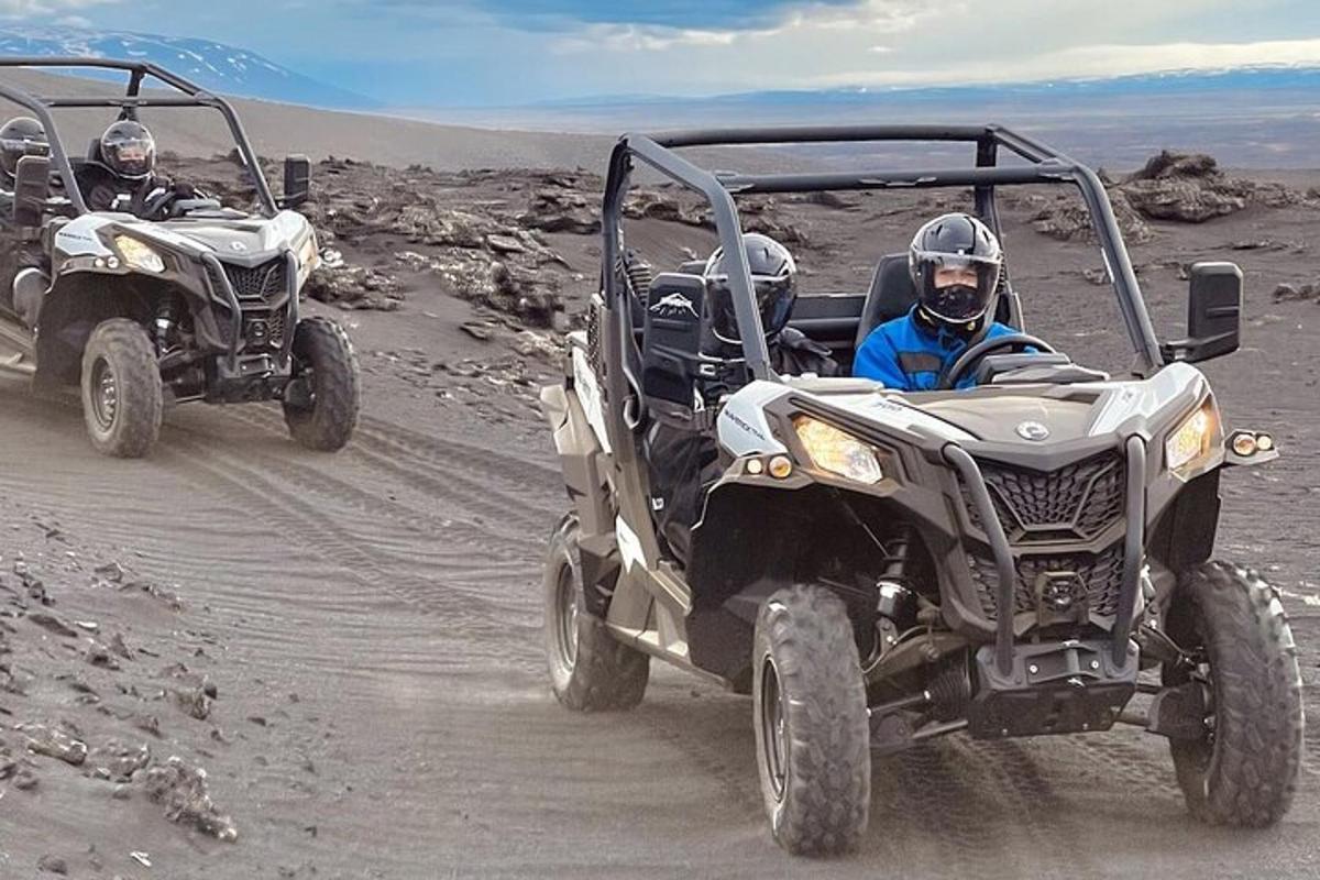 two men riding atvs on a dirt road