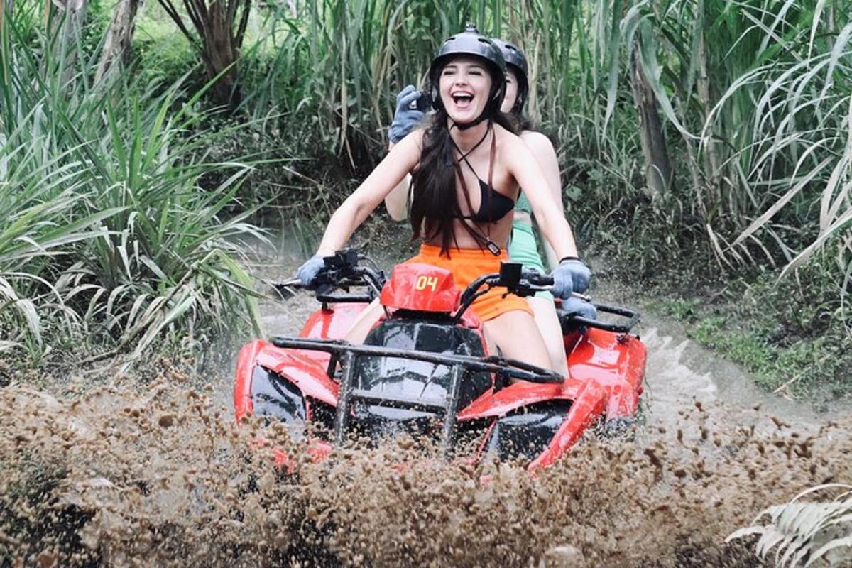 a woman riding on a four wheeler in the mud