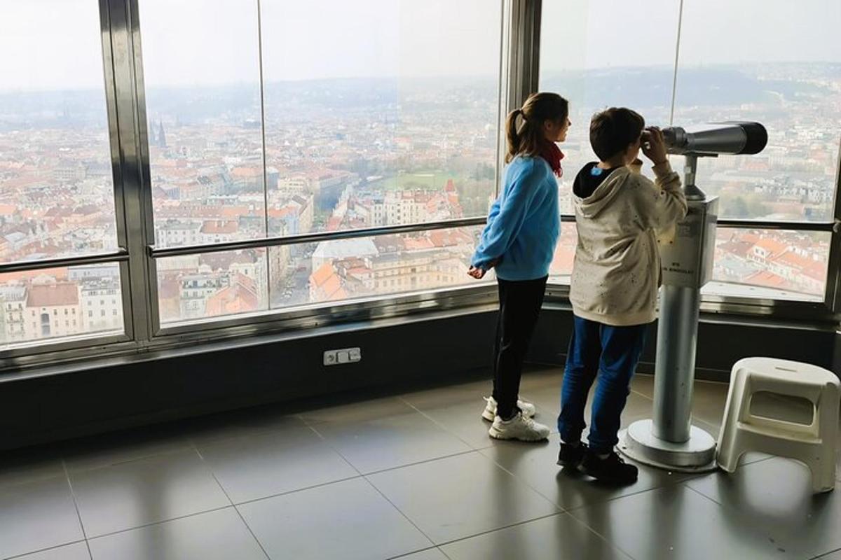 dvi merginos žiūri pro teleskopą pastate