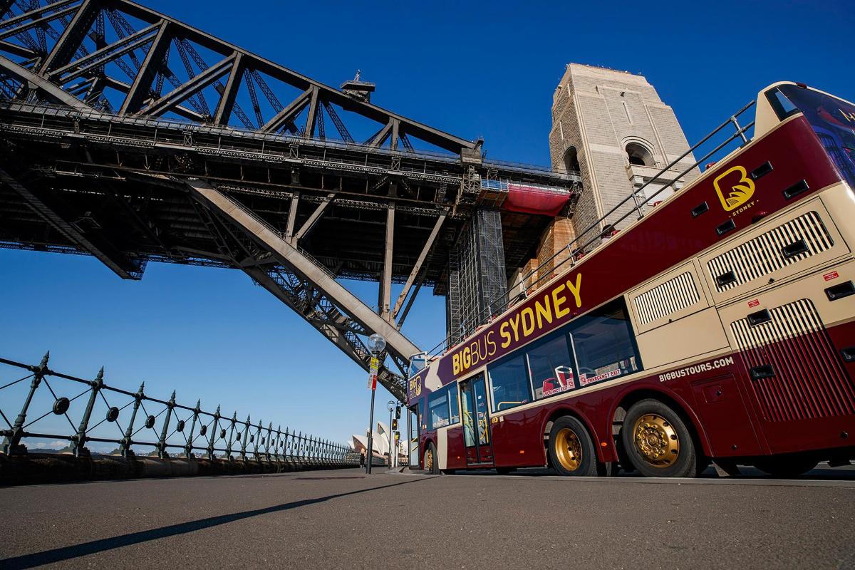 un autobus rosso a due piani parcheggiato sotto un ponte